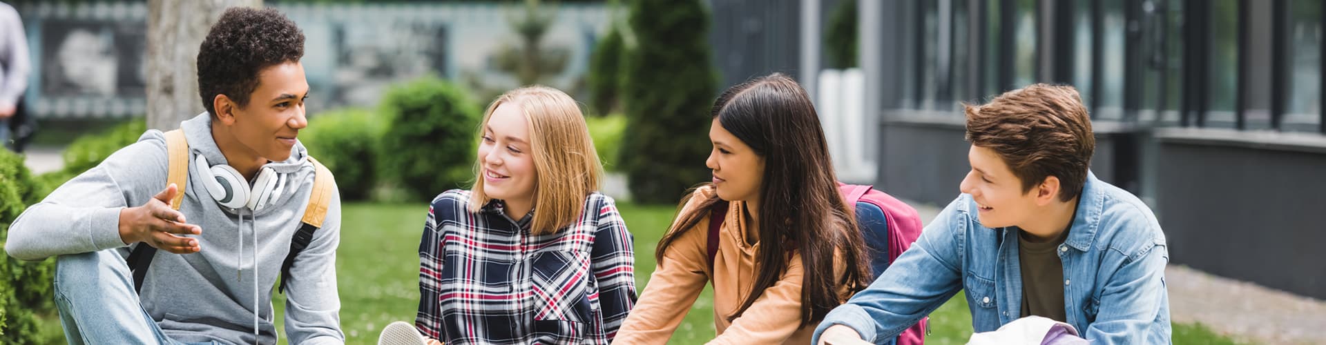 Teens sitting on grass in conversation